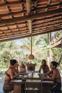 eine Gruppe von Frauen, die an einem Tisch sitzen in der Unterkunft Vila Fruta Pão in Caraíva