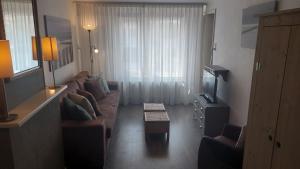 a living room with a couch and a coffee table at Appartement met inpandig balkon, 150 meter verwijderd van strand en centrum in Zoutelande
