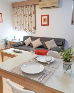 una sala de estar con una mesa con platos y copas de vino en Apartamentos Oasis Sol, en Maspalomas