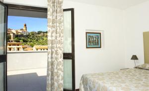 a bedroom with a bed and a large window at Hotel Lucerna in Castiglione della Pescaia