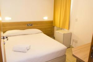 En eller flere senge i et værelse på Minuano Hotel Home próximo ao aeroporto