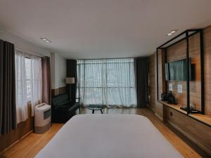 a bedroom with a large white bed and a window at Chill Suites in Ho Chi Minh City