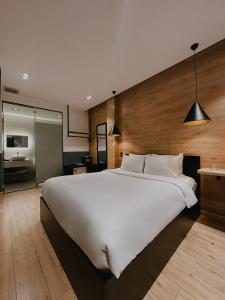 ein großes Schlafzimmer mit einem großen weißen Bett und einer Küche in der Unterkunft Chill Suites in Ho-Chi-Minh-Stadt