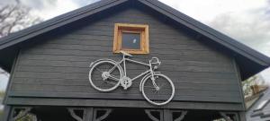 a bike is hanging on the side of a house at Domek nad jeziorem Drężno noclegi wynajem+sauna 