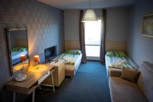 mały pokój z 2 łóżkami i lustrem w obiekcie Penzión Windšachta w mieście Štiavnické Bane