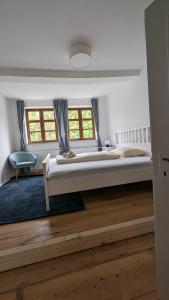 ein großes Schlafzimmer mit einem großen Bett und zwei Fenstern in der Unterkunft LIBORIA III Wohnen im Denkmal Augsburgs in Augsburg