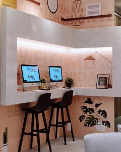 a desk with three computers on it in a room at Icasa By Gogo Hotel in Taichung