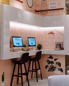 una scrivania con tre computer in una stanza di Icasa By Gogo Hotel a Taichung