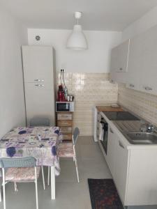 uma pequena cozinha com uma mesa e um lavatório em La Fregate em Roquebrune-Cap-Martin