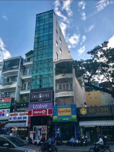 a tall building on a city street with buildings at Chotel Pham Ngu Lao in Ho Chi Minh City