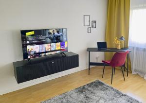 sala de estar con TV y silla roja en M&D Apartments nähe Volkspark mit Balkon - Netflix - Küche, en Kaiserslautern