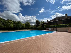 a swimming pool in a yard with a blue sky at Chalet Garda in Peschiera del Garda