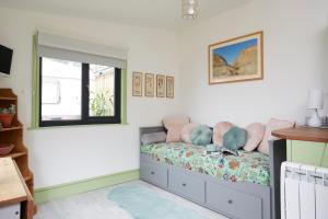 Schlafzimmer mit einem Bett und einem Fenster in der Unterkunft Puckaster Cove Cabin in Niton
