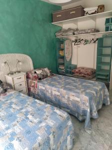 duas camas num quarto com paredes verdes em La Fregate em Roquebrune-Cap-Martin