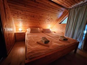 Una cama en una habitación de madera con dos sombreros. en Cottage Zoja, en Bohinjska Bistrica