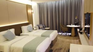 a hotel room with two beds and a table at H Luxury Hotel in Wadi Musa