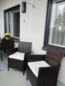 a patio with two chairs and a table and windows at Spa Hotel RED in Tahkovuori