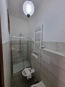 ein Bad mit einer Dusche, einem WC und einer Uhr in der Unterkunft Hostaria Zerø HR in Piedimonte dʼAlife