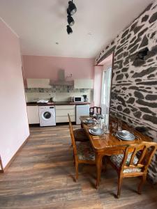 a dining room with a table and a stone wall at Appartements touristique - La Colombière in Lourdes