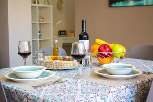 einen Tisch mit Teller und Schalen mit Obst und Weingläsern in der Unterkunft Eva's Residence, Family Apartment in Chania