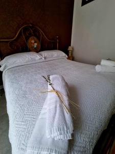 eine weiße Decke auf einem Bett mit einem Kopfteil aus Holz in der Unterkunft Hostaria Zerø HR in Piedimonte dʼAlife