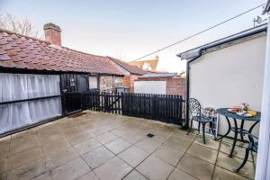 a patio with a table and a fence at Button Cottage in Wickham Market