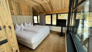 a bedroom with a bed and a flat screen tv at Amus Suites Dolomites in Anterselva di Mezzo