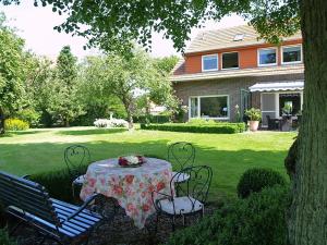 einen Tisch und Stühle im Hof eines Hauses in der Unterkunft Pension Landart in Wangerland