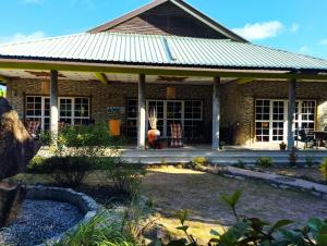 a brick house with a porch and a yard at Elje Villa in La Digue