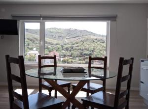mesa de comedor con 2 sillas y ventana grande en EiraDouro Casa Amendoeira, 
