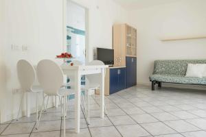 a room with a table and chairs and a couch at Residence Ola in Milano Marittima