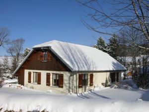 una casa con techo cubierto de nieve en Gîte de la Marandine in Métabief with garden, en Métabief