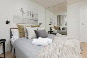 a white bedroom with a bed and a mirror at Cosy Dream City Center Apartment by Renters in Warsaw