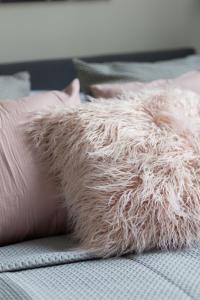 a person laying on a bed with a pile of fur at Cosy Dream City Center Apartment by Renters in Warsaw