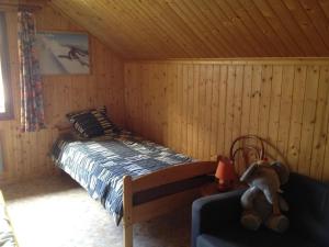 ein Schlafzimmer mit einem Bett und einem Sofa in einer Hütte in der Unterkunft Gîte de la Marandine in Métabief with garden in Métabief