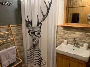 a bathroom with a shower curtain with a reindeer on it at Lilly Chalet- Apartments with private sauna, close to ski lifts in Bad Kleinkirchheim