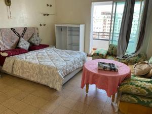 a bedroom with a bed and a table and a couch at إقامة 16 ساحة الامم in Tangier