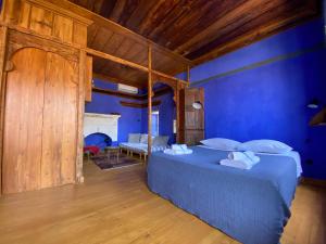 Schlafzimmer mit blauen Wänden und einem Bett mit Kissen in der Unterkunft Kasa Antika in Megisti