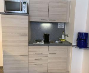 a small kitchen with a sink and a microwave at Chiemgau Appartements in Inzell