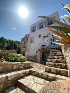 - un bâtiment blanc avec des escaliers devant dans l'établissement Kasa Antika, à Megísti