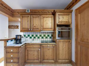 a kitchen with wooden cabinets and a sink at Appartement Méribel, 3 pièces, 4 personnes - FR-1-566-37 in Les Allues