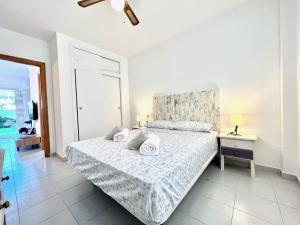 a white bedroom with a bed and a window at Bungalow Los Balcones in Torrevieja