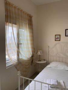 a bedroom with a bed and a window at Aliki's Apartments in Skala Kallonis +17 photos