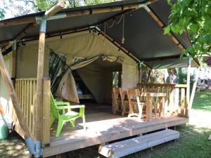 a gazebo with chairs and tables in it at Camping Le Mondou in Saint-Julien-de-Lampon