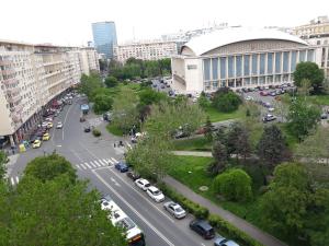 a city street with cars parked in front of a building at The Best Location Accommodation in Bucharest