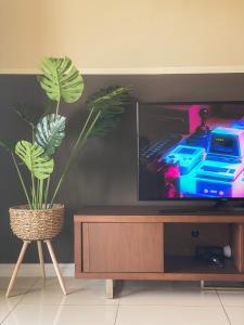 a living room with a tv and a plant at Maison life 小居屋 The Loft Imago in Kota Kinabalu