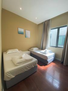 sypialnia z 2 łóżkami i oknem w obiekcie Maison life 小居屋 The Loft Imago w mieście Kota Kinabalu