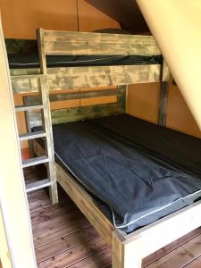 um beliche num quarto com uma escada em Camping Le Mondou em Saint-Julien-de-Lampon