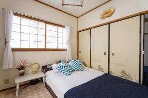 a bedroom with a bed and a window at Yoshidoku Inn Domemae 1 - Close to USJ World Airport 吉徳家庭旅館1 京セラドーム前 -近USJ -空庭温泉-難波-心斎橋-関西空港大阪駅梅田駅乗り換えなし-荷物の預かり無料-近く駐車場多い in Osaka