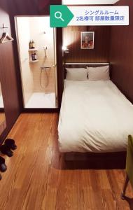 1 dormitorio con 1 cama y baño con ducha en Petit Hotel mio en Saitama